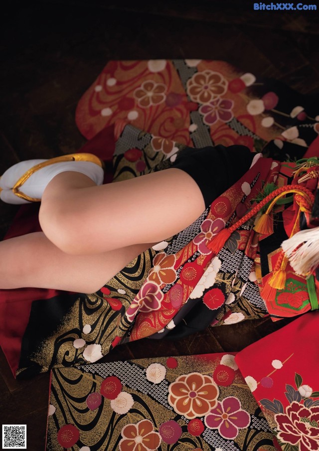 A woman in a kimono laying on the floor.