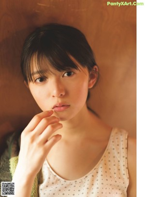A young woman sitting on a couch in a room.