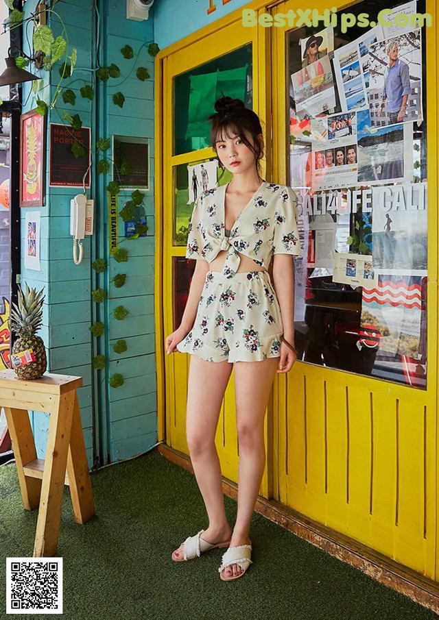 A woman standing in front of a yellow door.