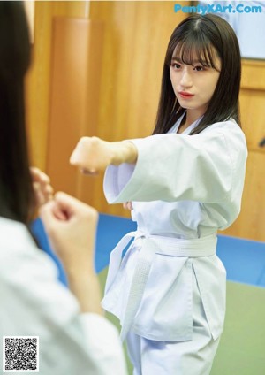 A woman in a white kimono is posing for a picture.