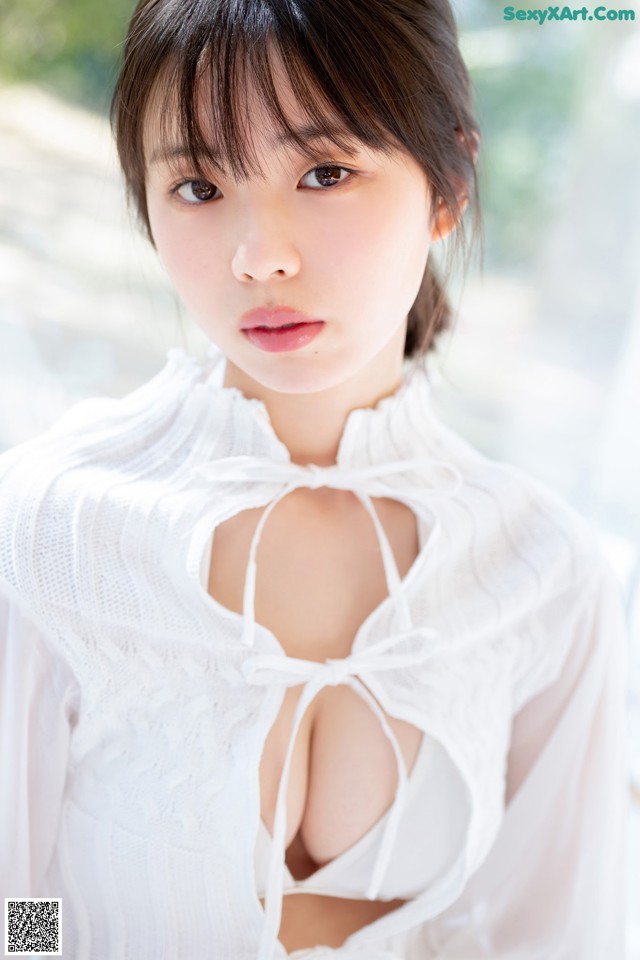 A woman in a white blouse posing for a picture.