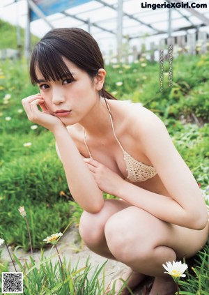 A young woman laying on the floor with her hand on her chin.