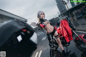 A woman in a black leather outfit holding a sword.