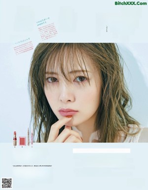 A woman in a white shirt is posing for a magazine.