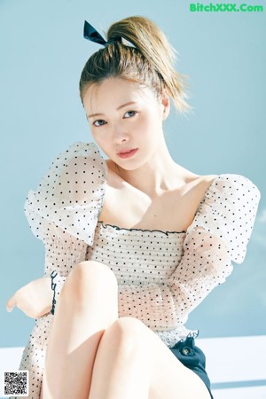 A woman in a black dress posing for a magazine.