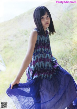 A woman with long black hair wearing a colorful dress.