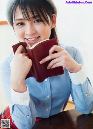 A woman sitting at a table reading a book.