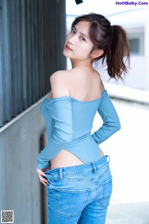 A woman sitting on a wooden deck wearing a white bra and panties.