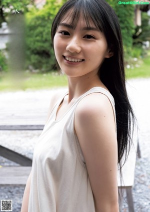 A woman in a blue shirt is posing for a magazine.