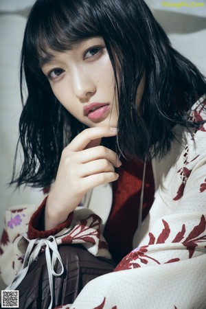 A woman in a red and white kimono standing on a balcony.