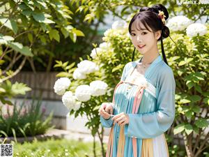 A woman in a pink and blue hanbok is posing for a picture.